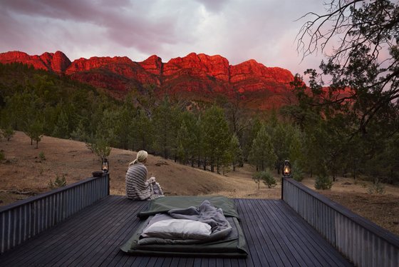 Frau sitzt beim Sonnenaufgang in Australien