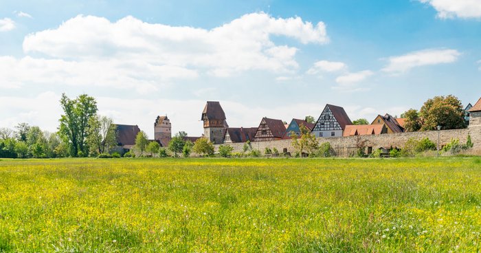 Skyline von Dinkelsbühl in Bayern mit dem Wahrzeichen Bäuerlinsturm und der historischen Stadtmauer.