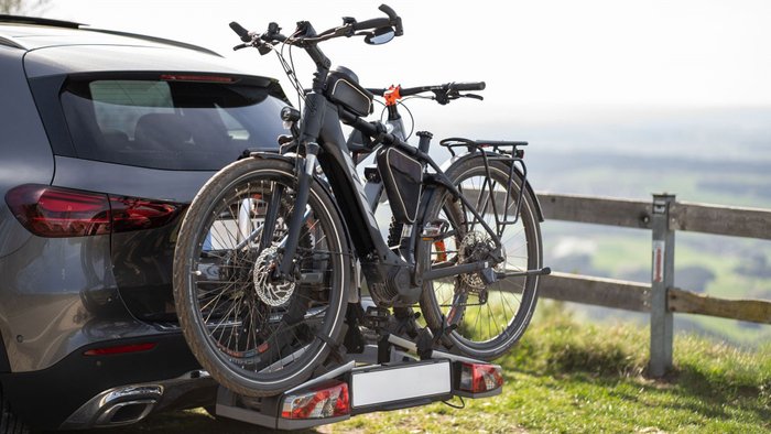 Pkw transportiert Fahrrad auf einem Fahrradträger auf der Anhängerkupplung.