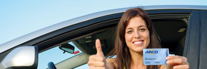 Junge Frau im Auto zeigt Clubkarte.