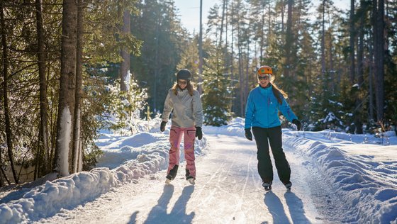 Zwei Frauen fahren Schlittschuh im Wald