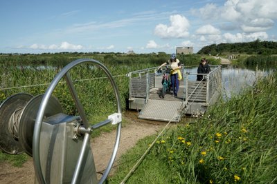 Zwei Personen an einer Seilfähre am Flussarm des Skjern Å.