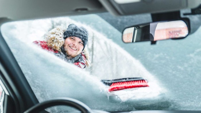 Frau schaut durch halb gekratzte Scheibe ins Auto rein.